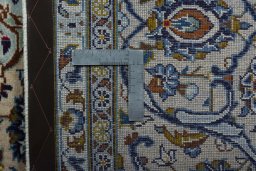 Backside of handmade 2000s Kashan rug showing knot structure and weave density