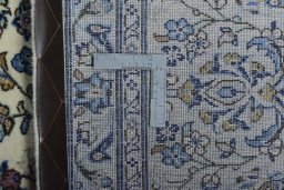 Backside of handmade New Kashan rug showing knot structure and weave density