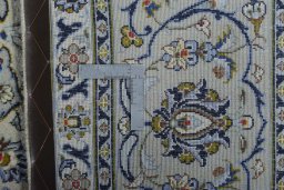 Backside of handmade 2000s Kashan rug showing knot structure and weave density