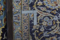 Backside of handmade 2000s Kashan rug showing knot structure and weave density