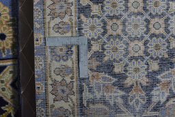 Backside of handmade 2000s Kashan rug showing knot structure and weave density