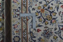 Backside of handmade 2000s Kashan rug showing knot structure and weave density