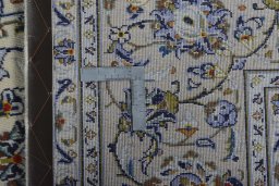 Backside of handmade 2000s Kashan rug showing knot structure and weave density