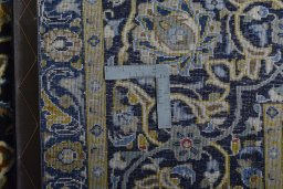 Backside of handmade 2000s Kashan rug showing knot structure and weave density