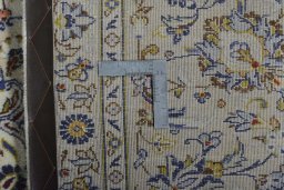 Backside of handmade New Kashan rug showing knot structure and weave density