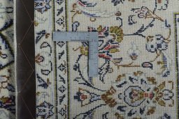 Backside of handmade 2000s Kashan rug showing knot structure and weave density