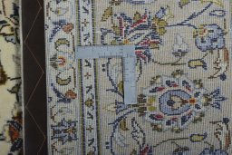 Backside of handmade 2000s Kashan rug showing knot structure and weave density