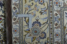 Backside of handmade New Kashan rug showing knot structure and weave density