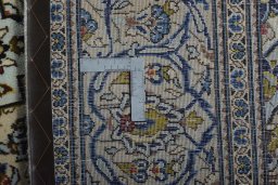 Backside of handmade 2000s Kashan rug showing knot structure and weave density