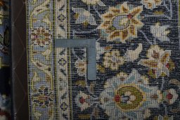 Backside of handmade 2000s Kashan rug showing knot structure and weave density