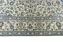Corner detail of 2000s Kashan rug showing border pattern and Wool pile
