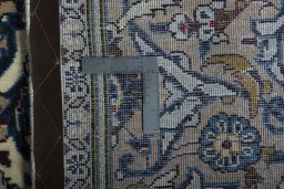 Backside of handmade 2000s Kashan rug showing knot structure and weave density