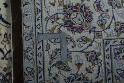 Backside of handmade 2000s Kashan rug showing knot structure and weave density