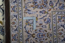 Backside of handmade 2000s Kashan rug showing knot structure and weave density