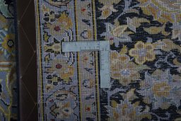 Backside of handmade 2000s Kashan rug showing knot structure and weave density
