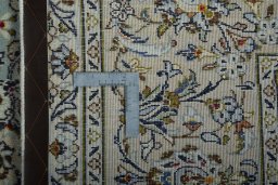 Backside of handmade 2000s Kashan rug showing knot structure and weave density
