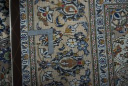 Backside of handmade 2000s Kashan rug showing knot structure and weave density
