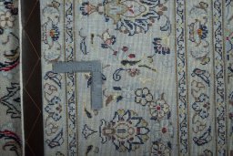 Backside of handmade New Kashan rug showing knot structure and weave density