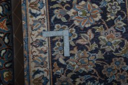 Backside of handmade 2000s Kashan rug showing knot structure and weave density