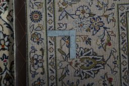 Backside of handmade 2000s Kashan rug showing knot structure and weave density