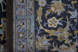 Backside of handmade 2000s Kashan rug showing knot structure and weave density