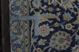 Backside of handmade 2000s Kashan rug showing knot structure and weave density