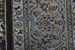 Backside of handmade 2000s Kashan rug showing knot structure and weave density