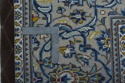 Backside of handmade 2000s Kashan rug showing knot structure and weave density