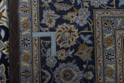 Backside of handmade 2000s Kashan rug showing knot structure and weave density