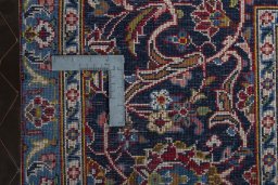 Backside of handmade 2000s Kashan rug showing knot structure and weave density