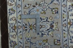 Backside of handmade 2000s Kashan rug showing knot structure and weave density