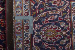 Backside of handmade 2000s Kashan rug showing knot structure and weave density