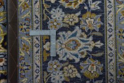 Backside of handmade 2000s Kashan rug showing knot structure and weave density