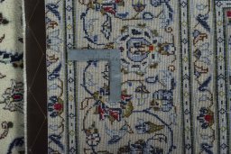 Backside of handmade 2000s Kashan rug showing knot structure and weave density