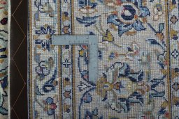 Backside of handmade 2000s Kashan rug showing knot structure and weave density