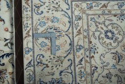Backside of handmade 2000s Kashan rug showing knot structure and weave density