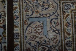 Backside of handmade 2000s Kashan rug showing knot structure and weave density