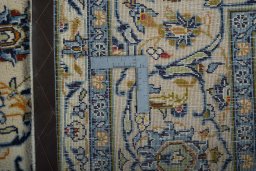 Backside of handmade 2000s Kashan rug showing knot structure and weave density