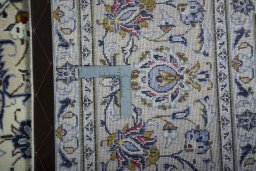 Backside of handmade 2000s Kashan rug showing knot structure and weave density