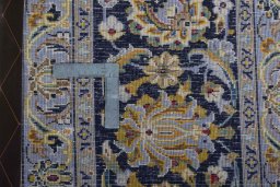 Backside of handmade 2000s Kashan rug showing knot structure and weave density