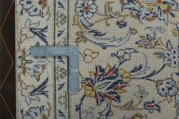 Backside of handmade 2000s Kashan rug showing knot structure and weave density