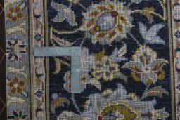 Backside of handmade 2000s Kashan rug showing knot structure and weave density
