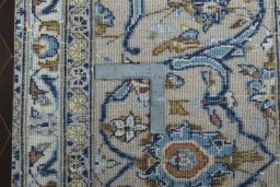 Backside of handmade 2000s Kashan rug showing knot structure and weave density