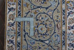 Backside of handmade 2000s Kashan rug showing knot structure and weave density