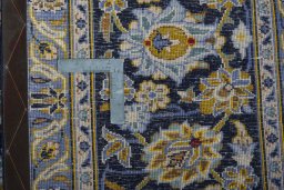 Backside of handmade 2000s Kashan rug showing knot structure and weave density
