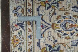 Backside of handmade 2000s Kashan rug showing knot structure and weave density