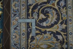 Backside of handmade 2000s Kashan rug showing knot structure and weave density