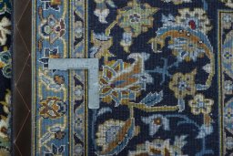 Backside of handmade 2000s Kashan rug showing knot structure and weave density