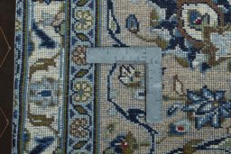 Backside of handmade 2000s Kashan rug showing knot structure and weave density