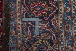 Backside of handmade 2000s Kashan rug showing knot structure and weave density